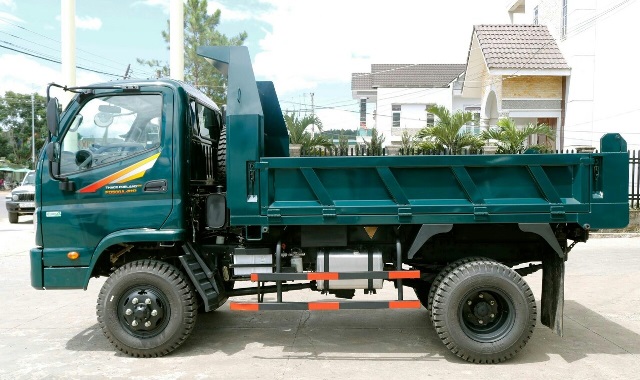 Hình ảnh thực tế xe ben Thaco Forland FD990 4WD - 5 tấn tại đại lý, nổi bật với thiết kế thùng ben 3 bửng và gương chiếu hậu đa hướng.